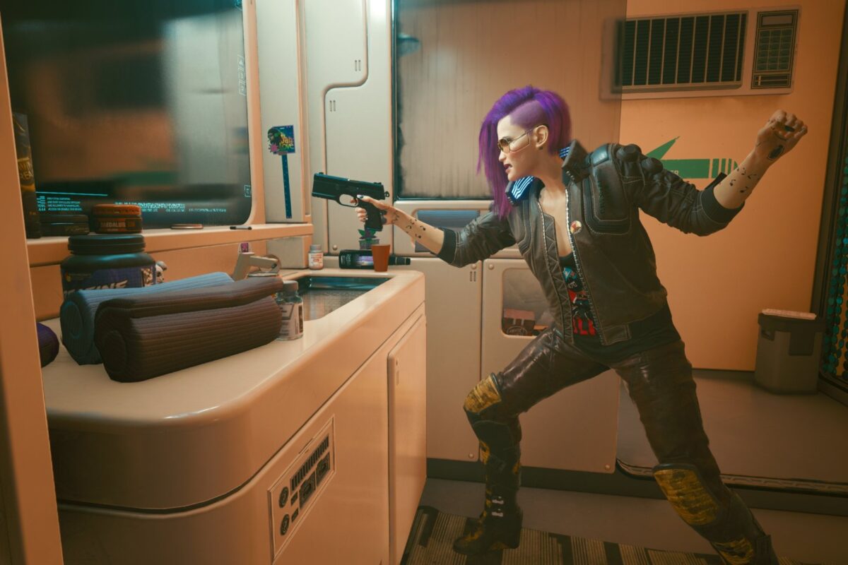 Weibliche Cyberpunk V in Militärklamotten und gezückter Pistole vor dem Spiegel.Screenshot aus dem Spiel Cyberpunk 2077 im Blog von Nastja der Mox.