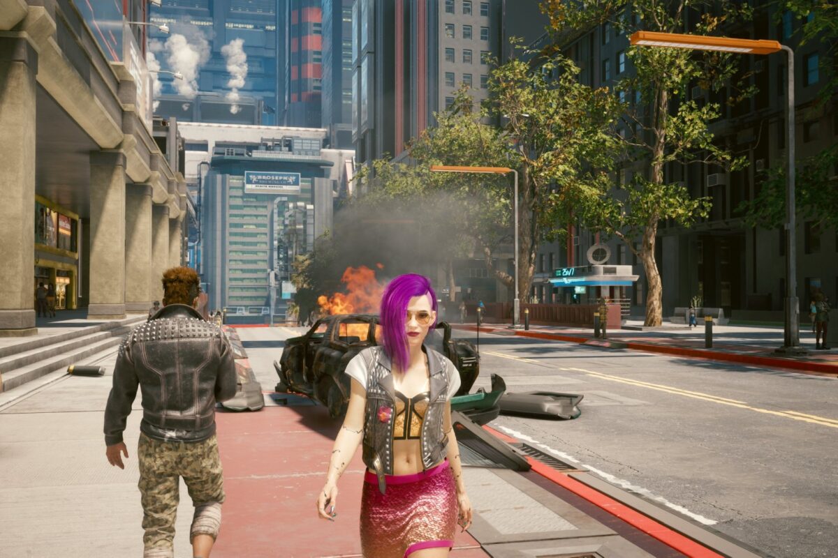 Weibliche Cyberpunk V unterwegs in Night City, im Hintergrund ein brenndenes Auto. Screenshot aus dem Spiel Cyberpunk 2077 im Blog von Nastja der Mox.