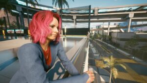Nachdenlliche Frau mit pinken Haare lehnt an ein Geländer. Screenshot aus dem Spiel Cyberpunk 2077 im Blog von Nastja der Mox. The Nameless of Night City ist eine Würdigung an die Ingame-NPCs.