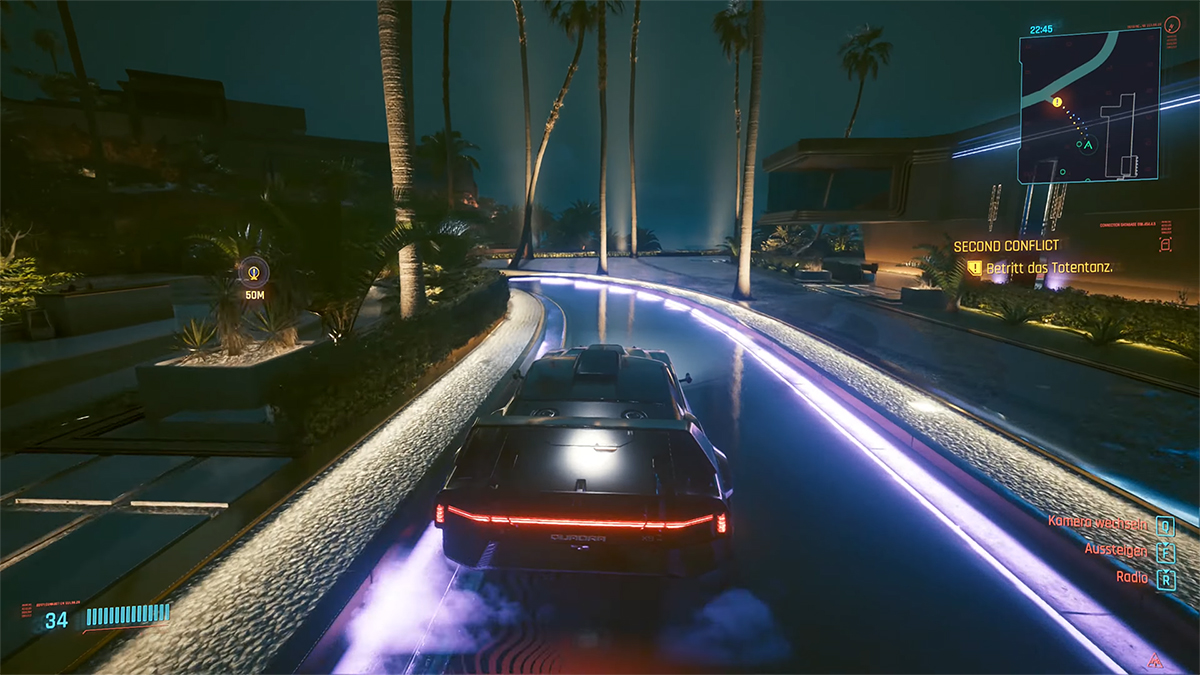 Dunkler Wagen auf beleuchteten Zufahrtsweg. Screenshot aus dem SPiel cyberpunk 2077