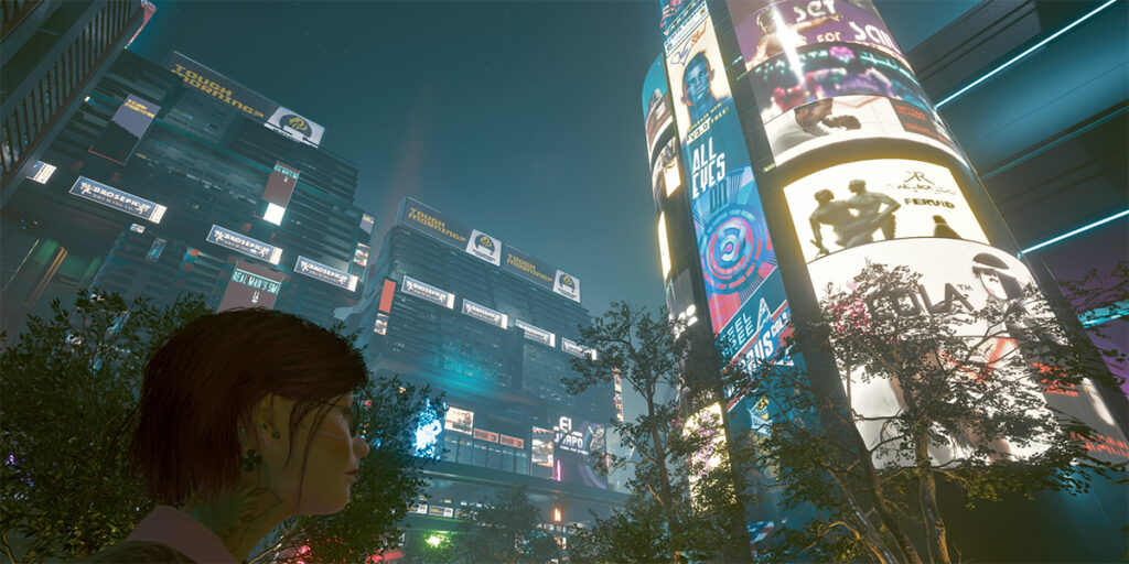 Night City bei Nacht. Eine Frau sieht grosse neon-beleuchtete Reklämesäule. Screenshot aus dem Spiel Cyberpunk 2077