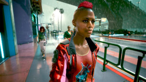Frau geht im regen durch Night City. Screenshot aus dem Spiel Cyberpunk 2077