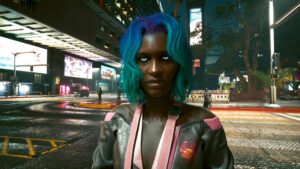 Dunkelhäutige Frau mit sehr leuchten blauen Augen. Screenshot aus dem Spiel Cyberpunk 2077.