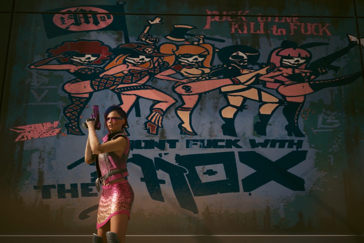 Cyberpunk V mit gezogener Handfeuerwaffe vor einem Mox-Graffity. Screenshot aus dem Spiel Cyberpunk 2077.