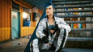 Blauhaarige Frau im Overall sitzt auf einer Treppe. Screenshot aus dem Spiel Cyberpunk2077